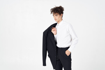 fashionable guy in a shirt and trousers with a jacket in his hand on a light background cropped view model Copy Space