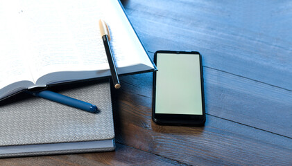 Open book with notepad and pen. Blank white screen. Office workplace