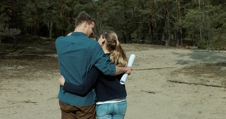 embraced couple choose a plot of land for dream house construction in forest