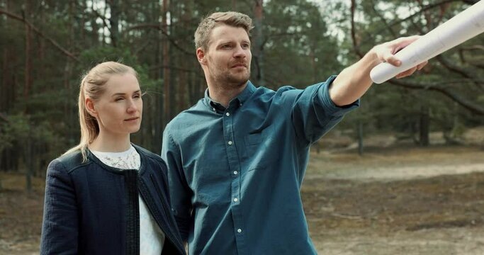 young couple looking and choosing a plot of land for house construction
