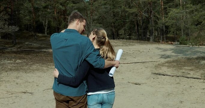 embraced couple choose a plot of land for dream house construction in forest