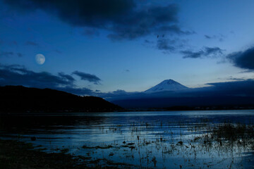 Cloud around mount Fuji with moon after sunset during winter season of Japan