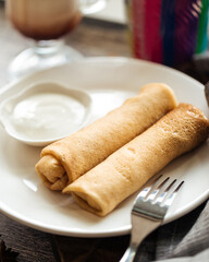 Closeup on russian national pancake rolls with sour cream