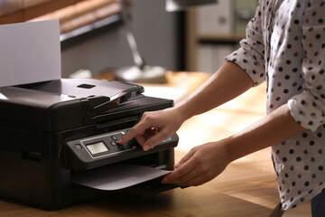 Employee using modern printer in office, closeup