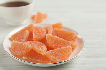 Tasty orange jelly candies on white table, closeup
