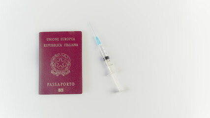 Italian passport and syringe with needle against coronavirus on white background. Meaning 