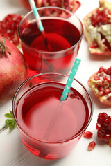 Pomegranate juice and fresh fruits on white table