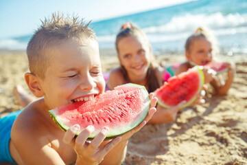 Children at sea. A group of children are eating a watermelon. High quality photo.