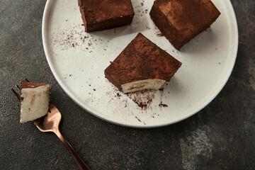 vanilla soufflé in chocolate on a round stylish plate.
square pieces of bird milk cake.