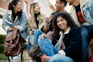 Group of happy university students having fun outdoors at campus.