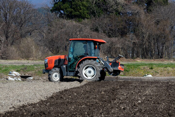 トラクターで田んぼを耕している男性　春　4月　田打ち