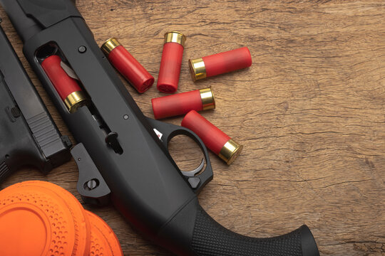 Semi Automatic shotgun and bullet shells on wooden background , Clay pigeons shooting game