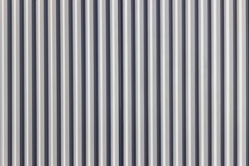 The fence is made of corrugated board. Alternating vertical black and white stripes.