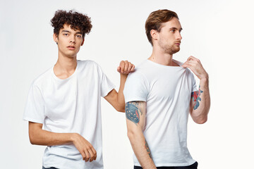 two men in white t-shirts stand side by side cropped view studio 