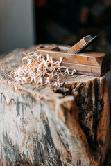 Old wooden jack plane with curly shavings. Wood shavings on old stump. Fresh curly sawdust. Wooden...