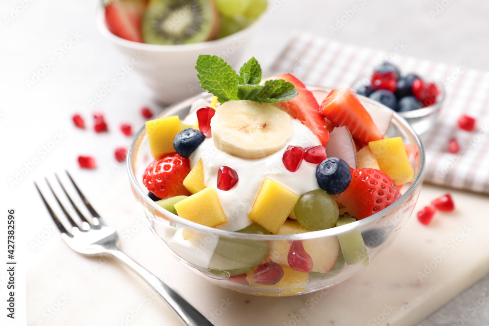 Wall mural delicious fruit salad with yogurt on light table - Wall murals