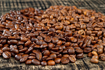 Coffee beans close up on a wooden board. Coffee on a black shabby table.