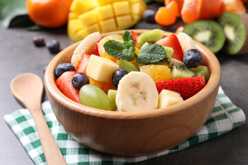 Delicious fresh fruit salad on grey table