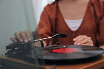 Woman using turntable at home, closeup view