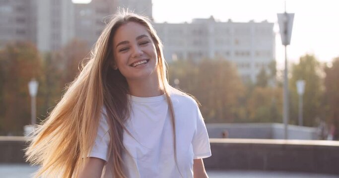 Portrait happy young female model student outdoors with surprised face feels delight shocked. Blonde girl joy pleasantly rejoices from good positive news dancing raising hands up in happiness says wow
