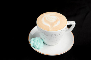 Cup of caramel latte coffee on black background. Delicious sweet sugar coffee