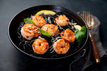 Spaghetti with shrimps and parmesan on dark background. Tasty appetizings seafood pasta.