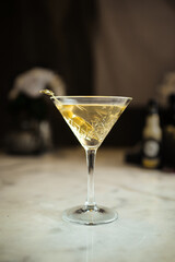 Side view on a glass of classic martini cocktail with olives