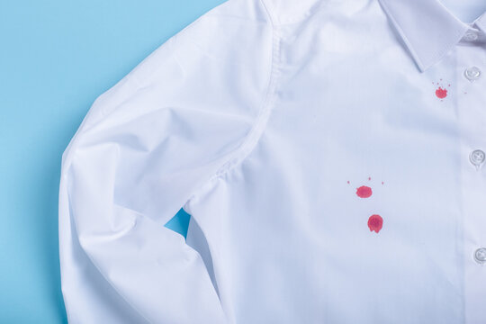 blood stain on clothes. isolated on blue background. top view