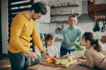 Happy family preparing healthy meal in the kitchen.