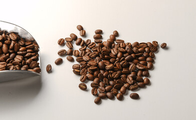 Pile of dark roasted coffee beans on white background