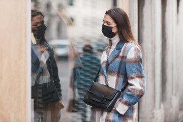 Woman with face mask looking at the shop window