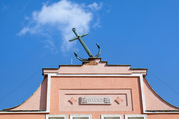 Anchor on the roof of a tenement house against a blue sky, architecture.