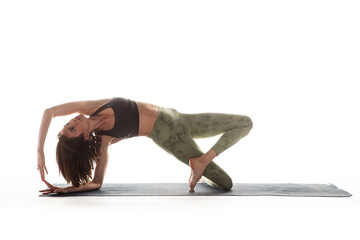 Woman doing yoga on yoga mat in studio