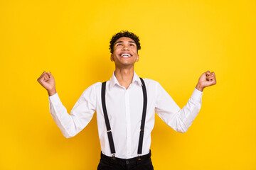 Fototapeta premium Photo portrait of african american man praying looking up celebrating isolated on vivid yellow colored background