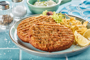 Homemade fish cutlets with fries and lemon