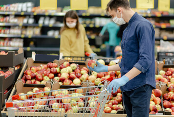 supermarket customers standing near the counter with apples.