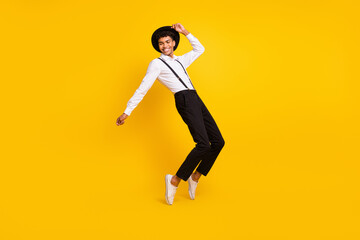 Fototapeta na wymiar Photo of carefree guy dance have festive fun wear headwear shirt suspenders isolated yellow color background
