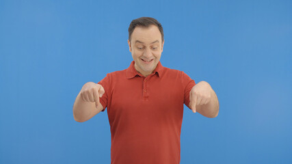 Young man pointing with two fingers in the advertising space under the screen. Swipe down gesture....