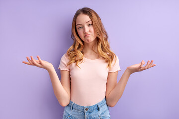 attractive girl misunderstanding, beautiful caucasian girl in casual wear shrugging, isolated on purple background