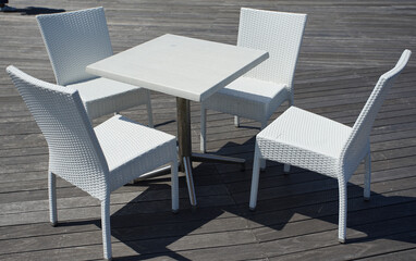 White chairs and table in the garden on a sunny day