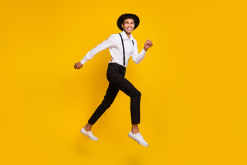 Fototapeta na wymiar Photo of energetic sporty guy jump run wear headwear shirt suspenders footwear isolated yellow color background