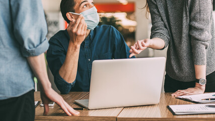 employees in protective masks discussing work issues.