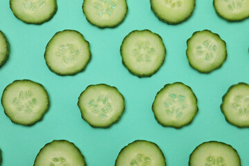 Fresh ripe cucumber slices on mint background