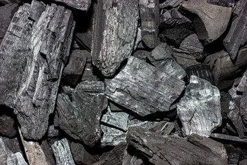 Black charcoal. Black charcoal texture. Pieces of charcoal top view. Charcoal barbecue.