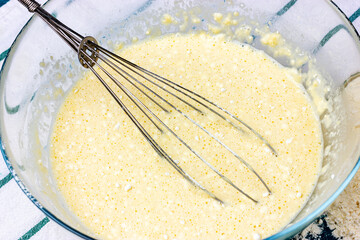Pancake dough kneading process. Hand whisk in a glass bowl of dough.
