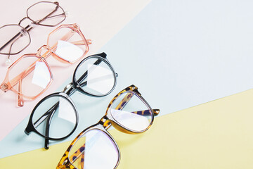 multiple eyeglasses on a multicolored background of pastel colors, geometric background, pink...