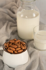 Vegetarian almond milk in bottle with almond  and glass of milk on a marble table.Alternative dairy.Rustic food photography.Still life.