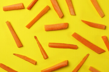 Slices of fresh carrot on yellow background