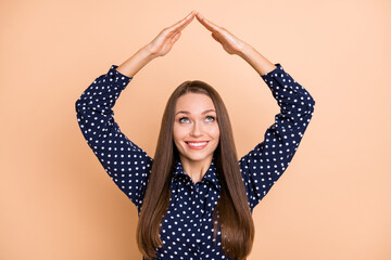 Photo of young woman happy positive hold hand roof home house buy moving look empty space isolated over beige color background