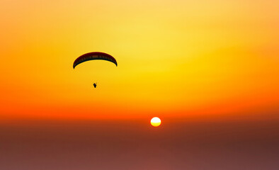 Paraglider flying in the beautiful sky against the background of clouds.